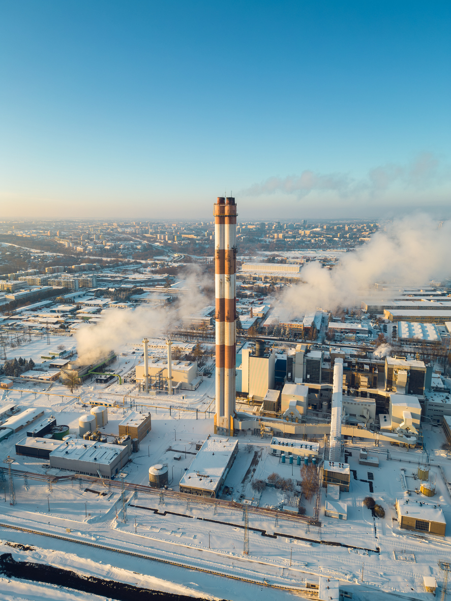 industrial aerial top view of heating power station during cold, snowy conditions